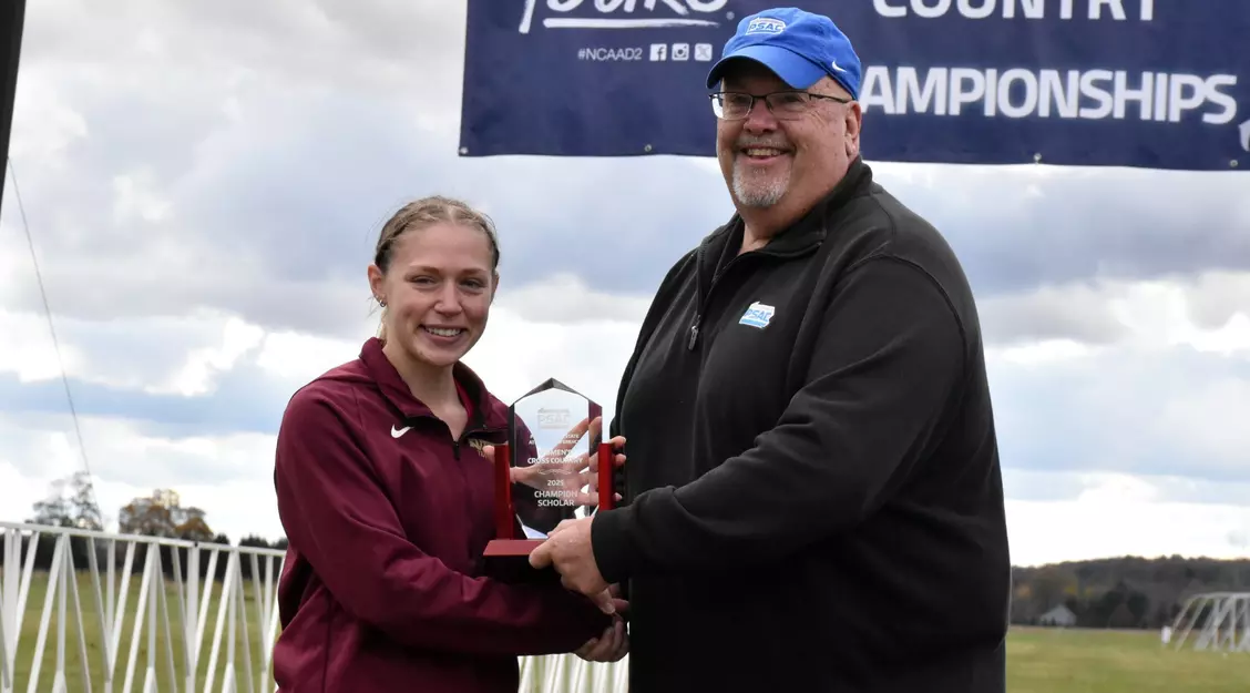 Sophia Knerr receives PSAC Champions Scholar Award from commissioner Steve Murray.