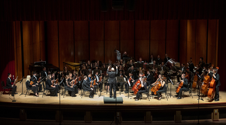 The Kutztown University Orchestra on a stage playing a concert.
