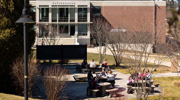 Students meeting at the outdoor classroom near deFrancesco Building