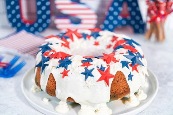 image of a bunt cake with white frosting and red and blue stars with a sign that says USA in the background