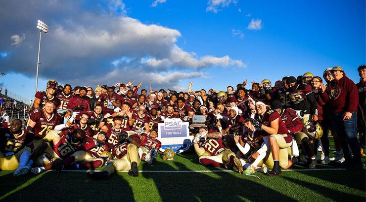 KU football team poses with PSAC trophy after winning the title.
