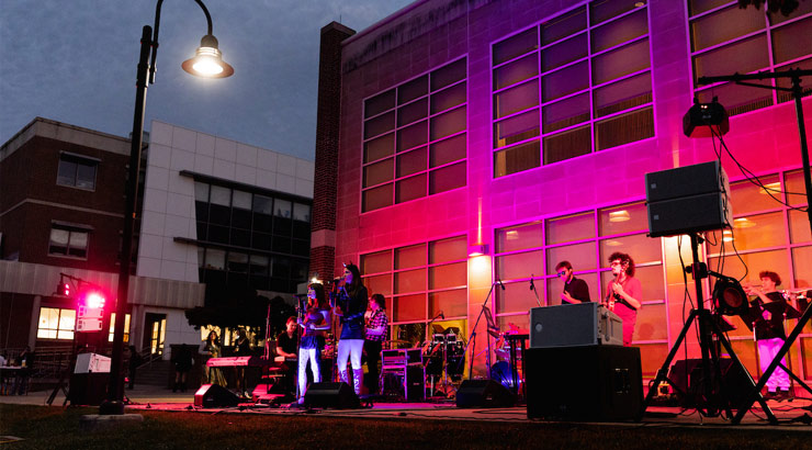students performing on stage outside Schaeffer Auditorium during Rock the Lawn event.