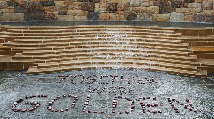 Alumni plaza waterfall, with the words "Together We're Golden" spelled out in the rocks.