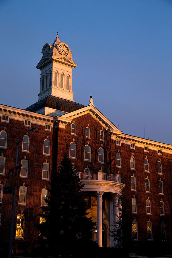 The old main tower against a clear blue sky basqued in the glow of an evening sunset.