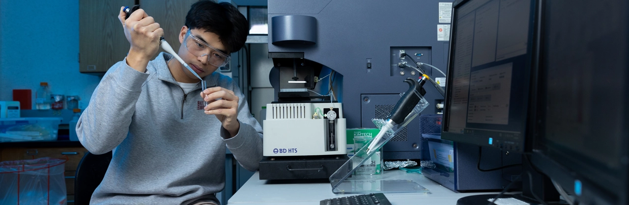 a kutztown university faculty teaching two students in a biology lab classroom.