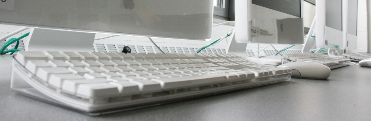 Image of a keyboard and mouse on a table in front of a monitor