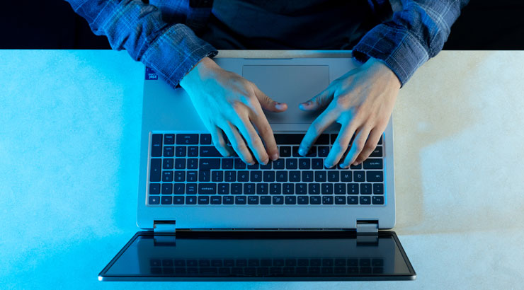 A male student working on a laptop computer