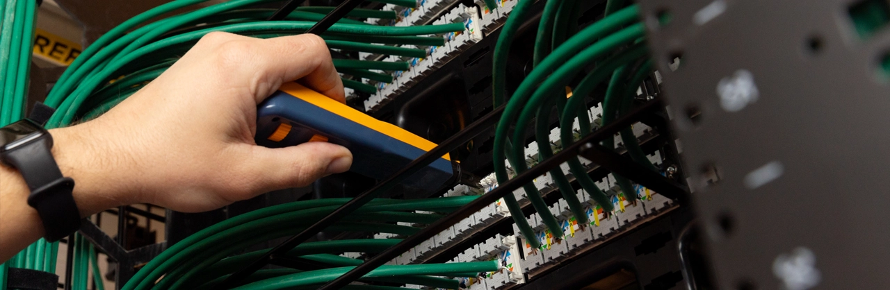 a hand of a person plugging hardware into a network stack