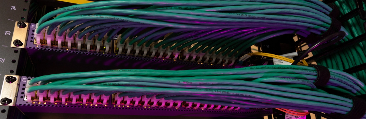 a networking rack with network wires going into multiple servers