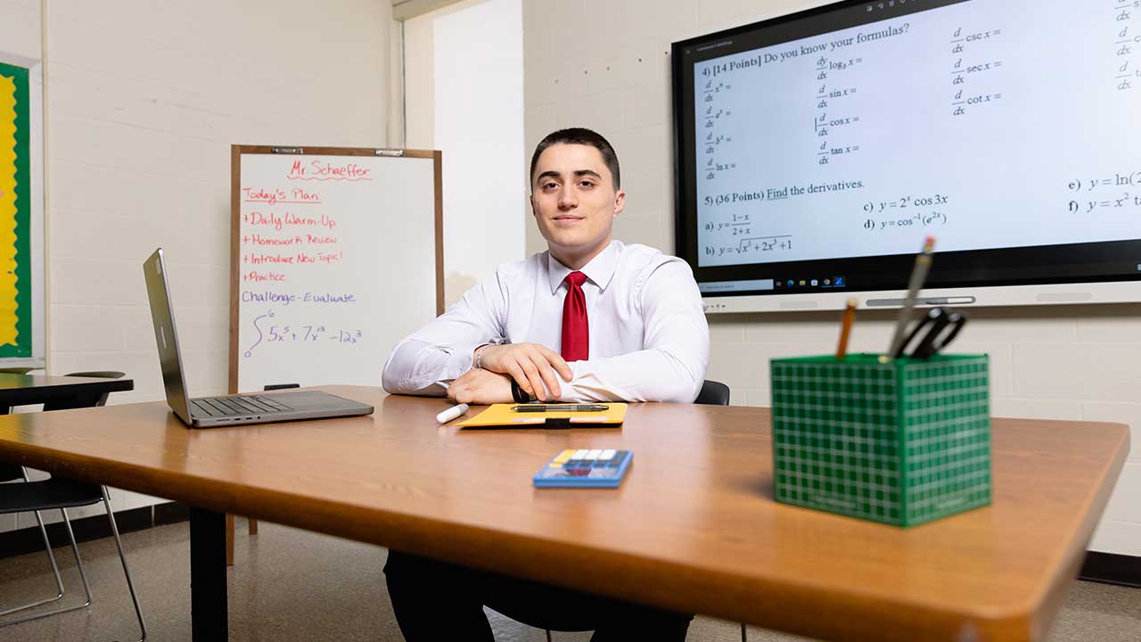 Secondary education student sitting at a desk in a classroom setting.