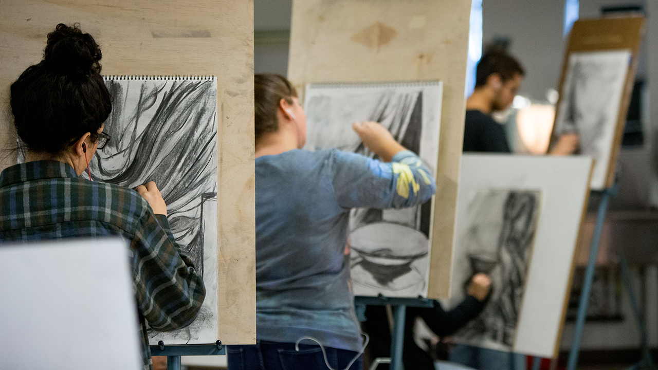 students working with charcoal to create artwork