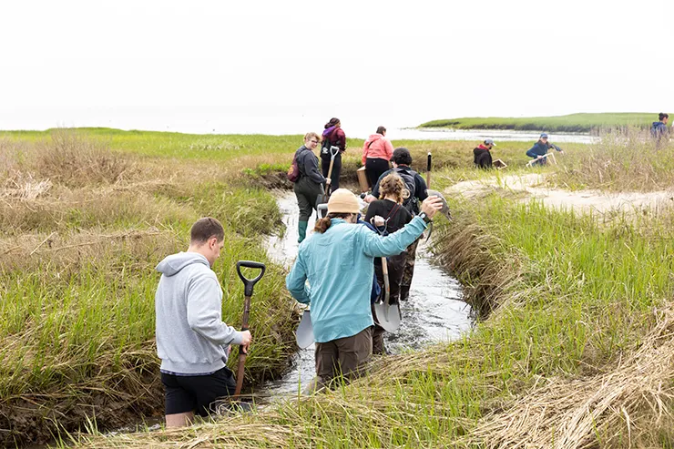students walk along a watery channel